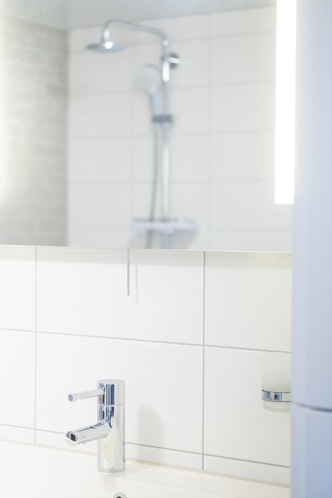 Lekkert bad med påkostede kraner og speil med godt sminkelys. Galleribilde