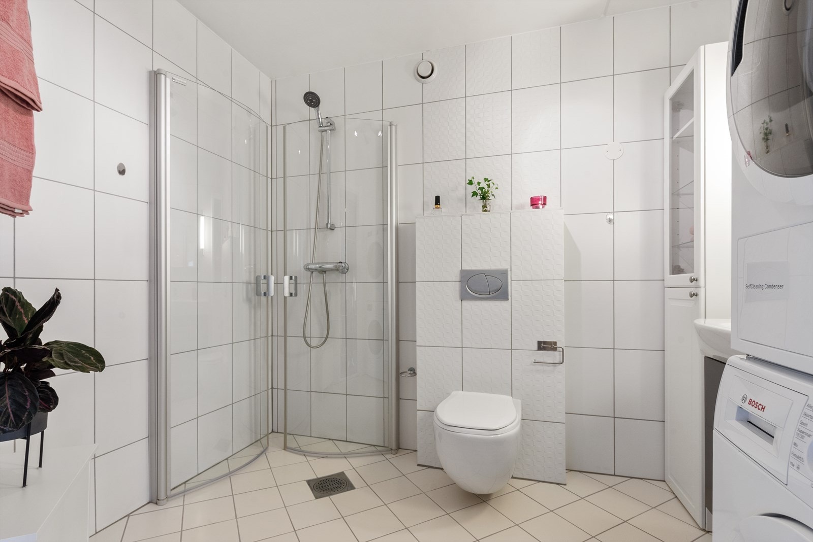 Her er det vegghengt toalett, servantskap, dusjhjørne med innfellbare glassvegger. Elektrisk håndkletørker og opplegg for vaskemaskin. Galleribilde