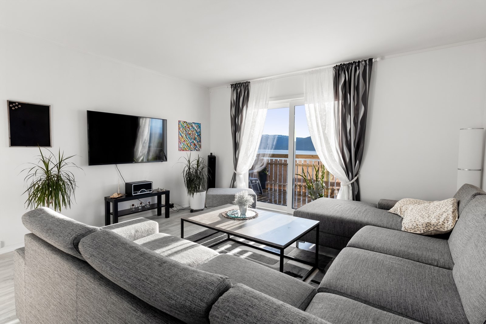 Stuen er lys og har store vindusflater som slipper inn rikelig med naturlig lys . I stuen har man plass til en stor sofagruppe. Galleribilde