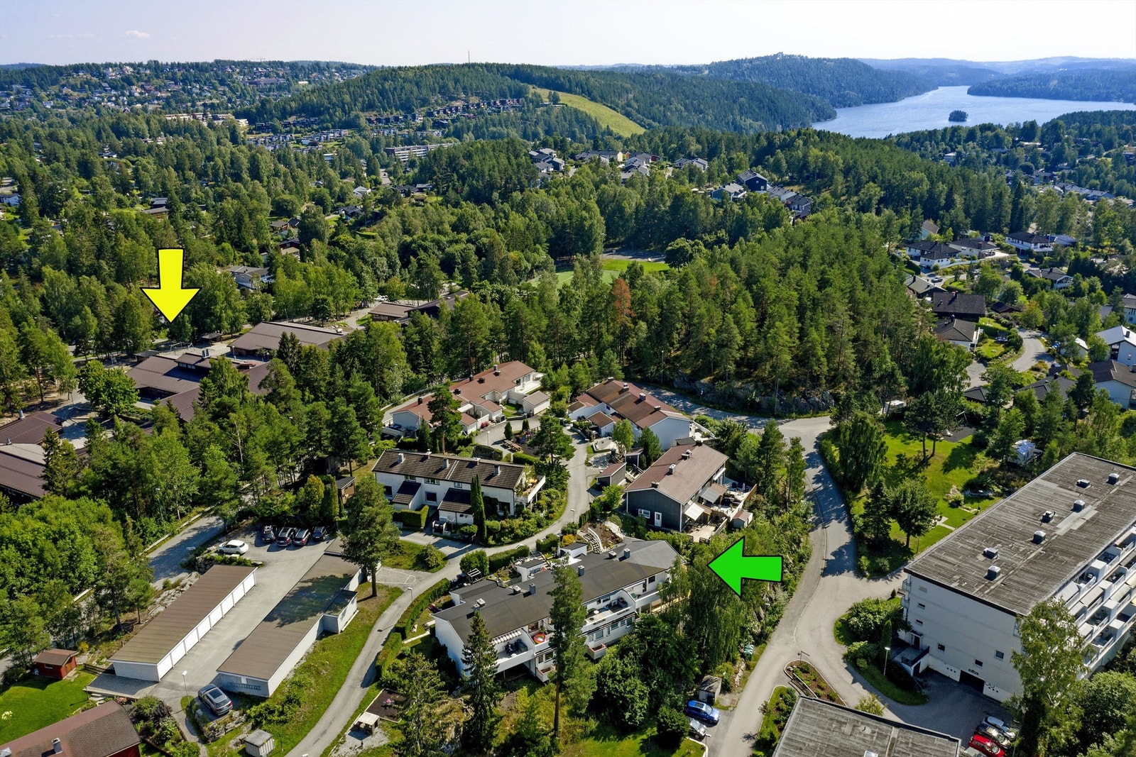 Dronefoto mot Ingierkollen og Gjersjøen - grønn pil viser boligen - gul pil viser Vassbonn barneskole (til høyre for skolen er fotballbane, ballbinge, m.m. Galleribilde