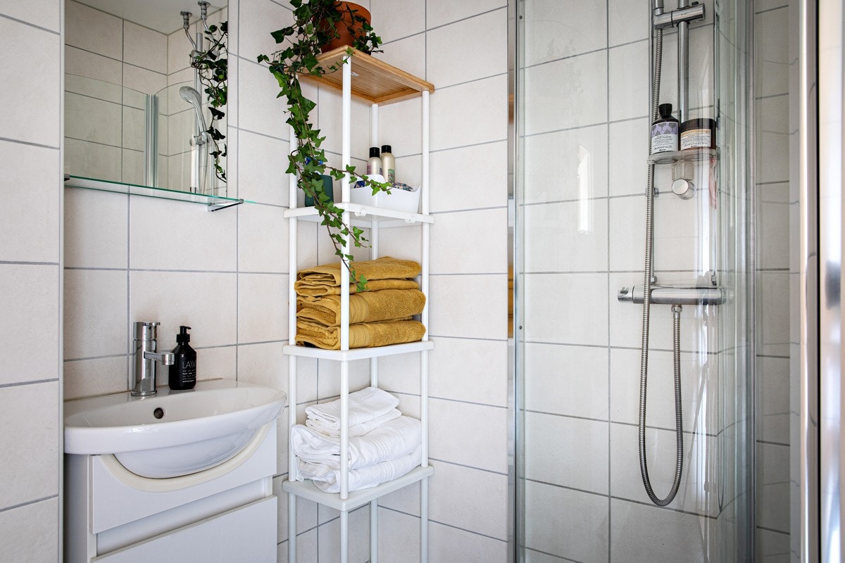 Badet er pent og tidløst, med beige, rektangulære fliser på vegg og mørkegrå, kvadratiske fliser på gulv. Galleribilde