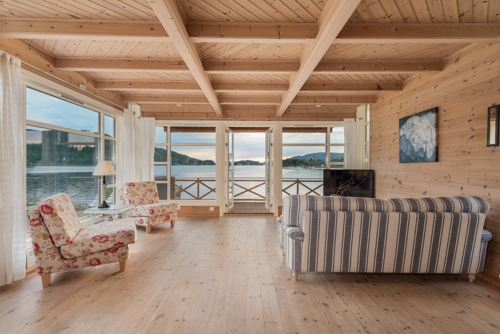 Store vinduer fra gulv til tak gir stuen en naturlig lysinnslipp. Galleribilde