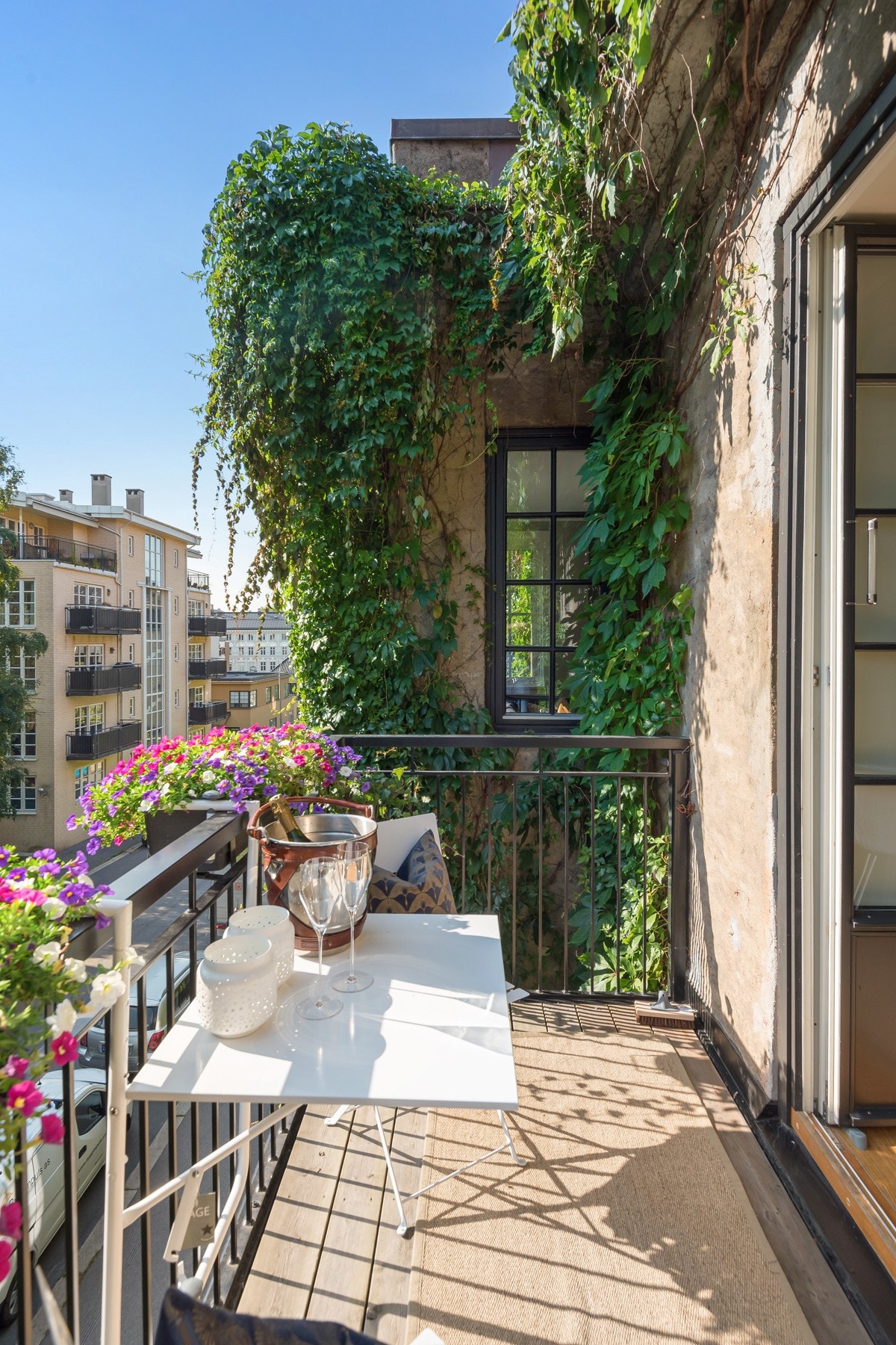 Hyggelig setting rundt balkongen med klatreplanter voksende på bygget Galleribilde