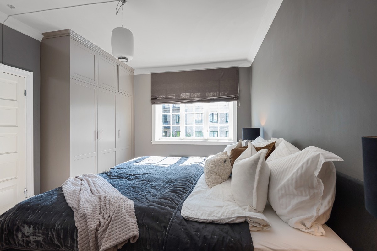 Herlig hovedsoverom med store takhøye snekkertilpassede garderobeskap i tillegg til et walk-in-closet Galleribilde