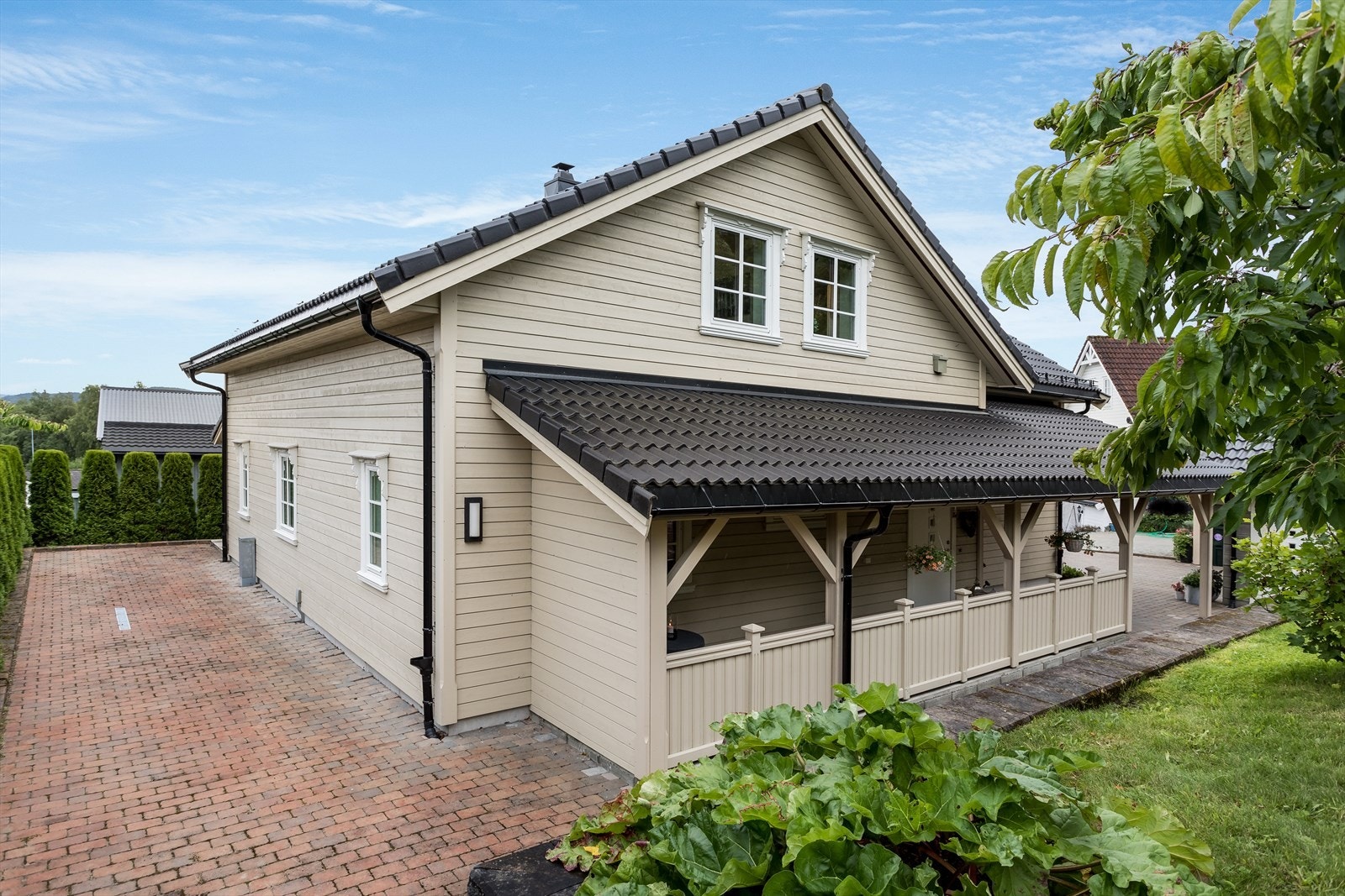 Tomten er lettstelt og er pent opparbeidet med belegningsstein, plen, bærbusker, frukttrær og thuja-hekk Galleribilde