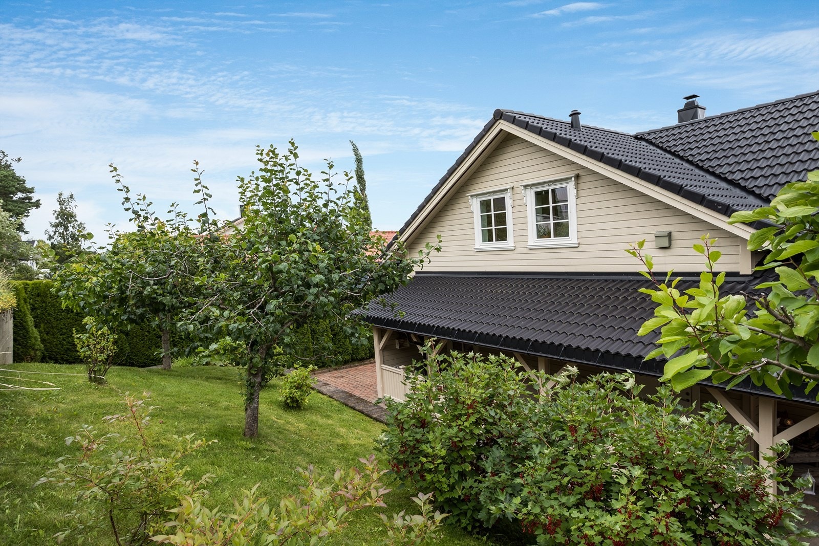 Tomten er pent opparbeidet med plen, frukttrær og bærbusker Galleribilde