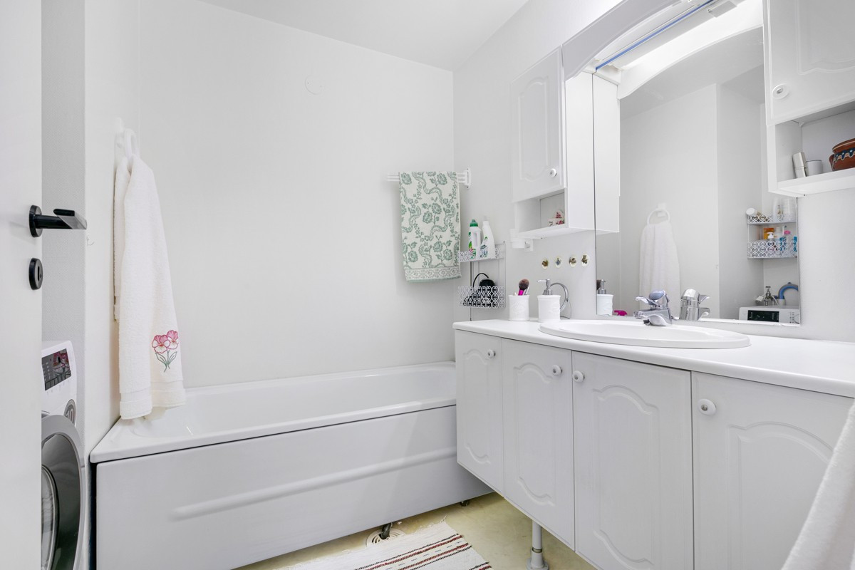 Badet er innredet med badekar og har opplegg for vaskemaskin
