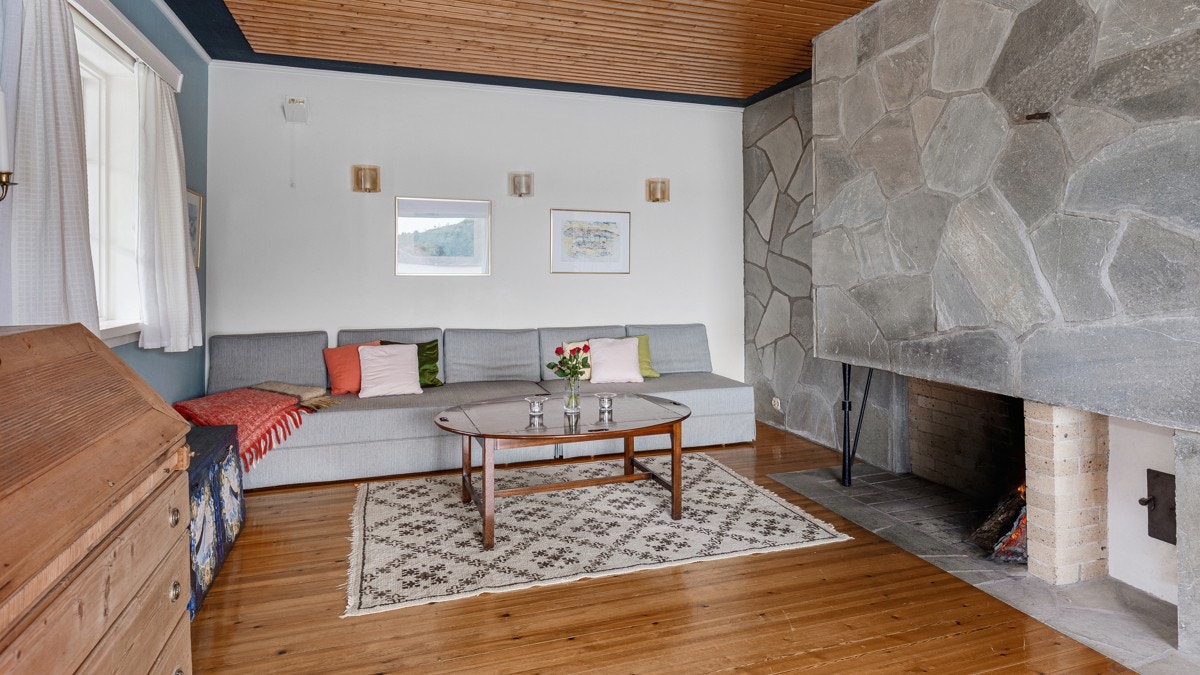 I den ene enden av stuen er det en lun krok med en koselig skiferbelagt peis som gir varme på kjølige kvelder Galleribilde