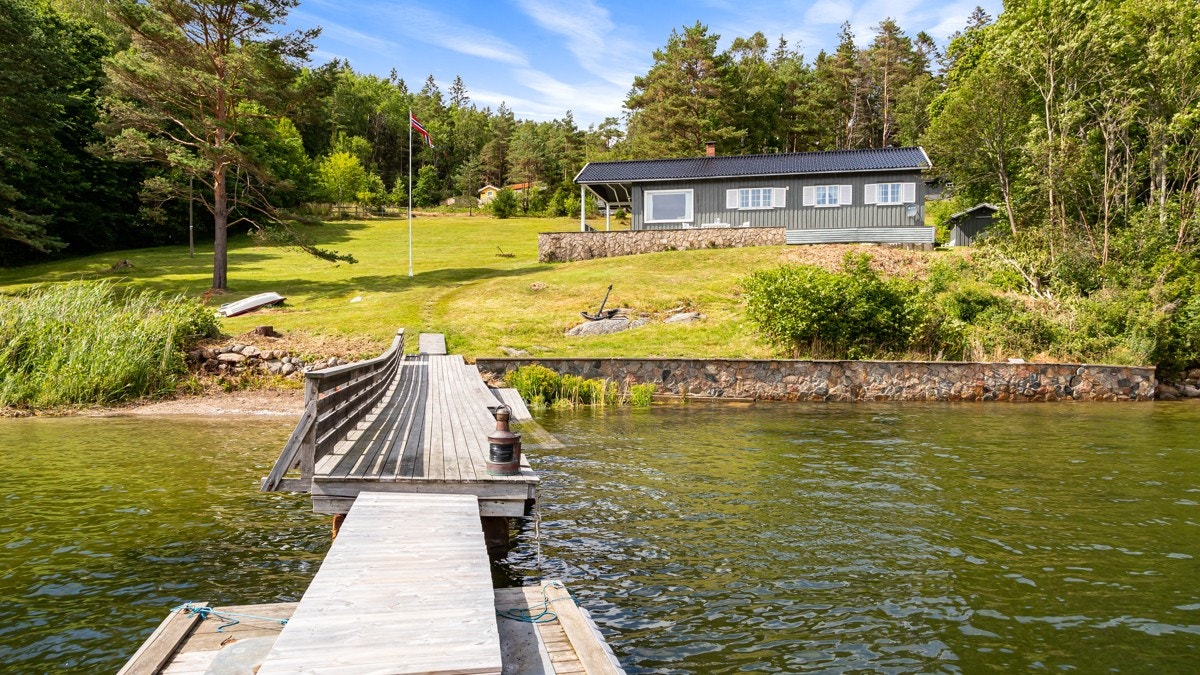 Med særegen beliggenhet rett i vannkanten, egen strandlinje, stor dypvannsbrygge og rikelig med boltreplass både inne og ute, er Grundvikveien 44 en helt unik fritidsbolig i Engelsviken. Galleribilde