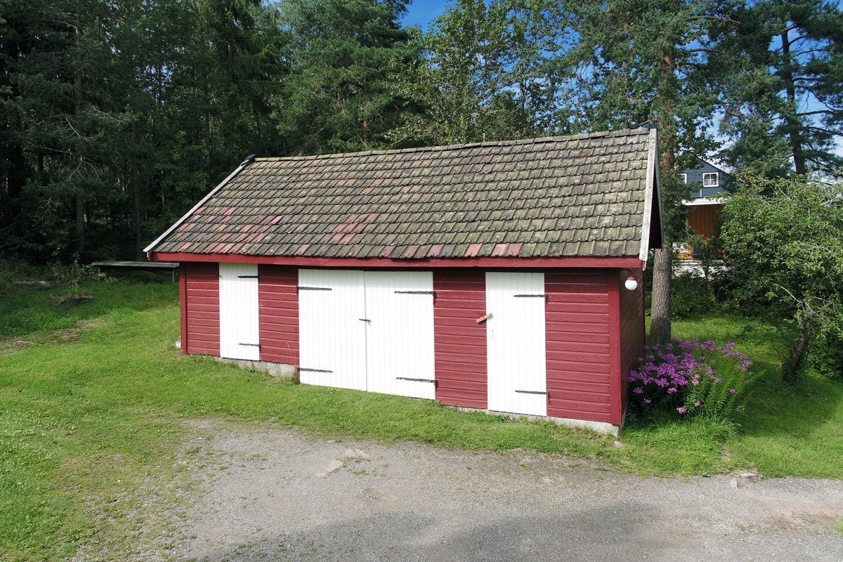 Uthus samt parkering i den grusede innkjørselen. Galleribilde