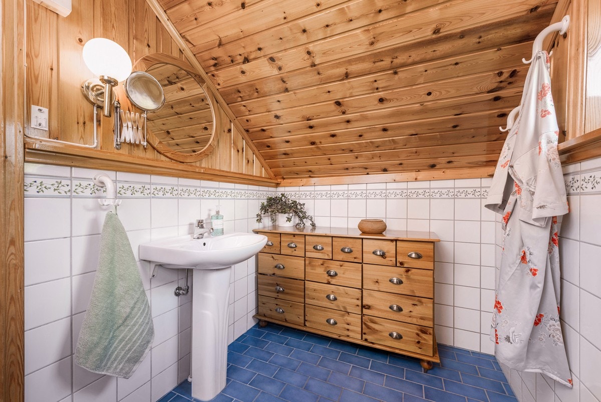 Badet har blå gulvfliser med underliggende varme. Galleribilde