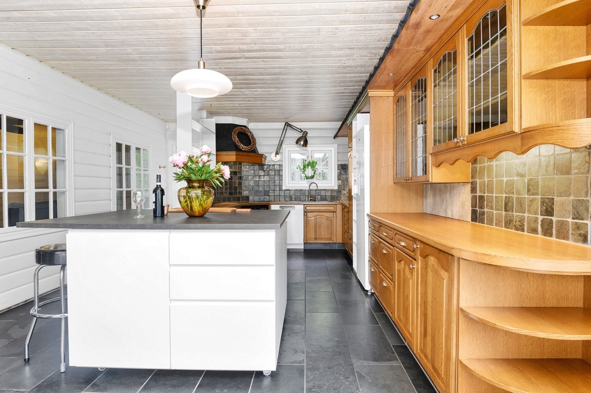 Romslig kjøkken med kjøkkenøy og innredning i eik Galleribilde