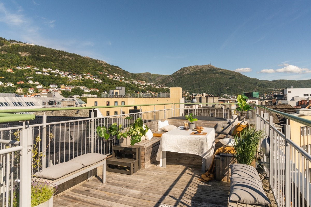 Dekket er bekledd med terrassebord og det er rekkverk av glass- og aluminium. Galleribilde