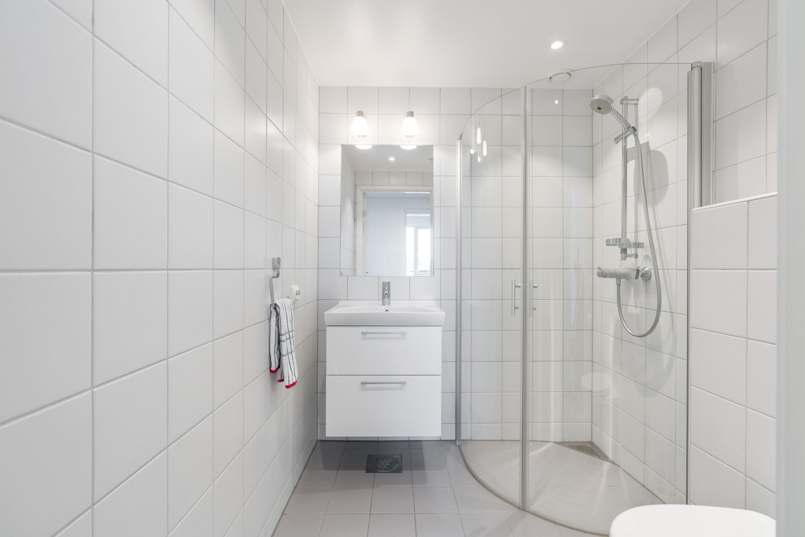 The second bathroom includes a shower, wash basin, WC and heated ceramic flooring. Galleribilde
