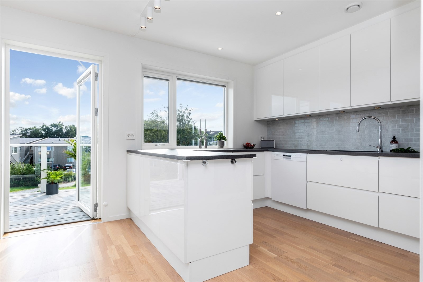 Nydelig innredning med fronter i tolinjet høyglans og mørk benkeplate Galleribilde