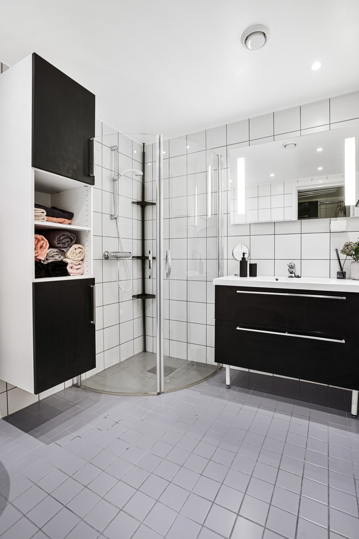 Badet er utstyrt med dushjørne, servant med speil, vegghengt toalett og godt med oppbevaring