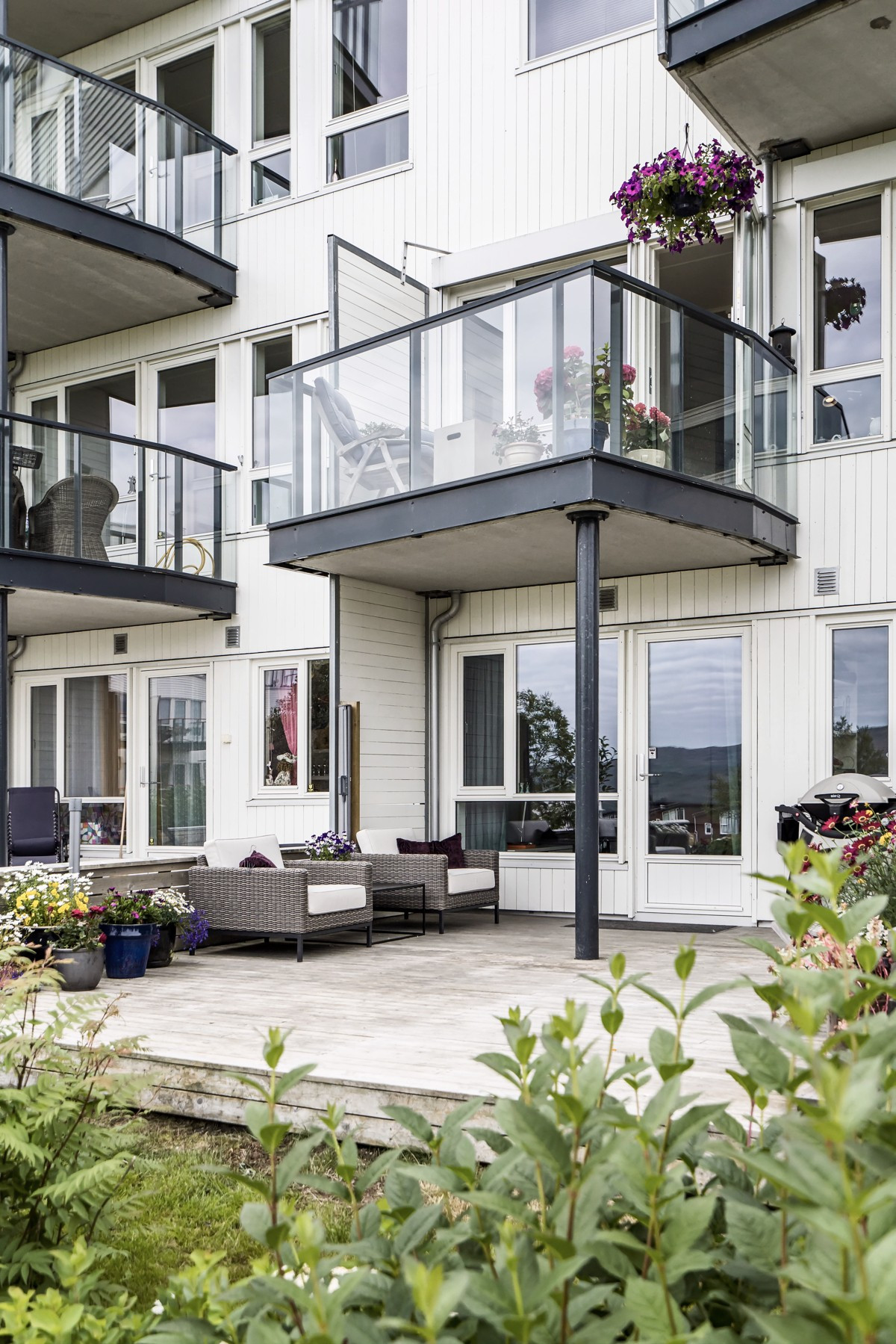Fasade sett fra forsiden med markterrasse og balkong
