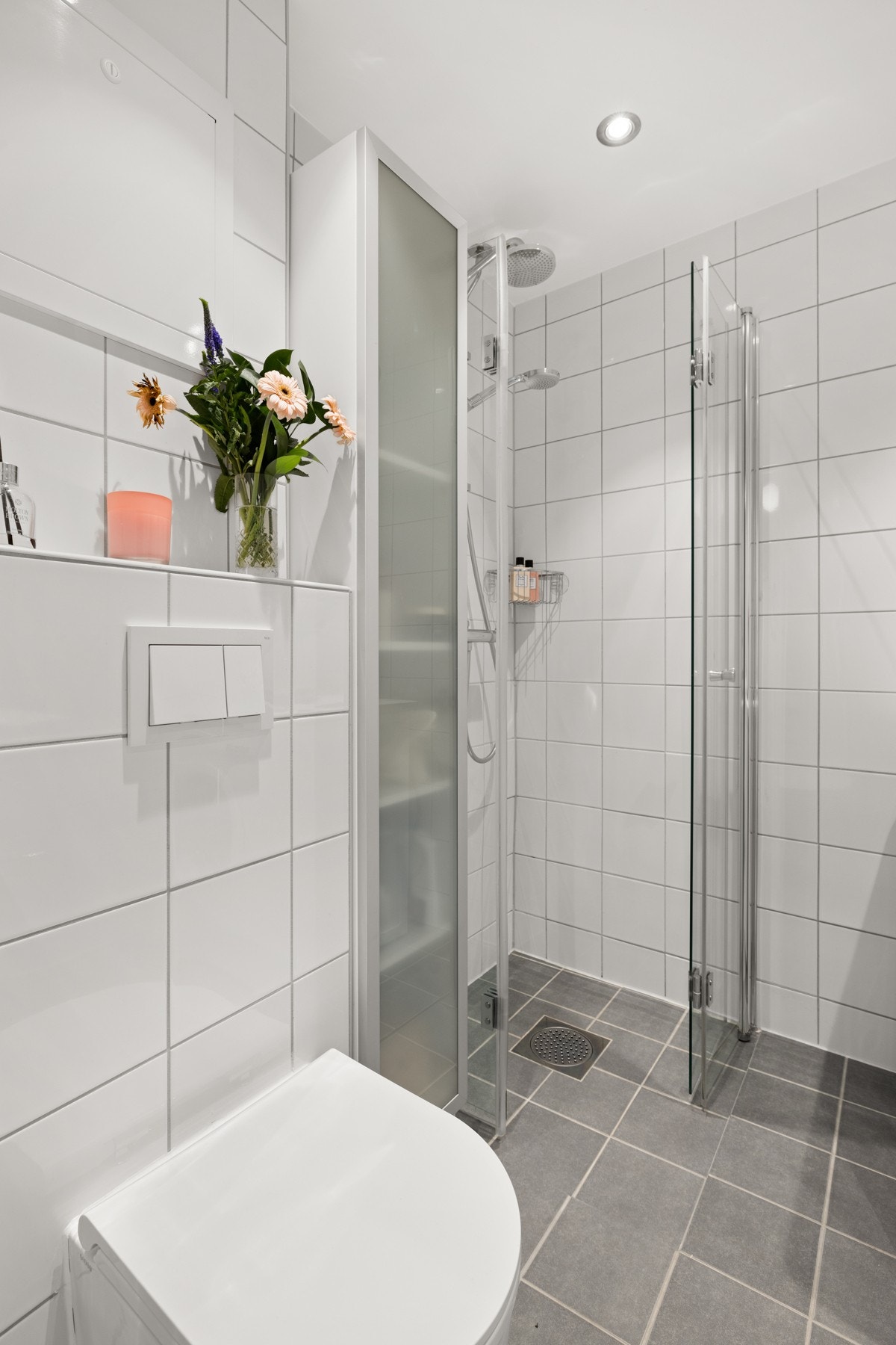 Videre er det dusjhjørne med foldbare glassdører og vegghengt toalett. Galleribilde