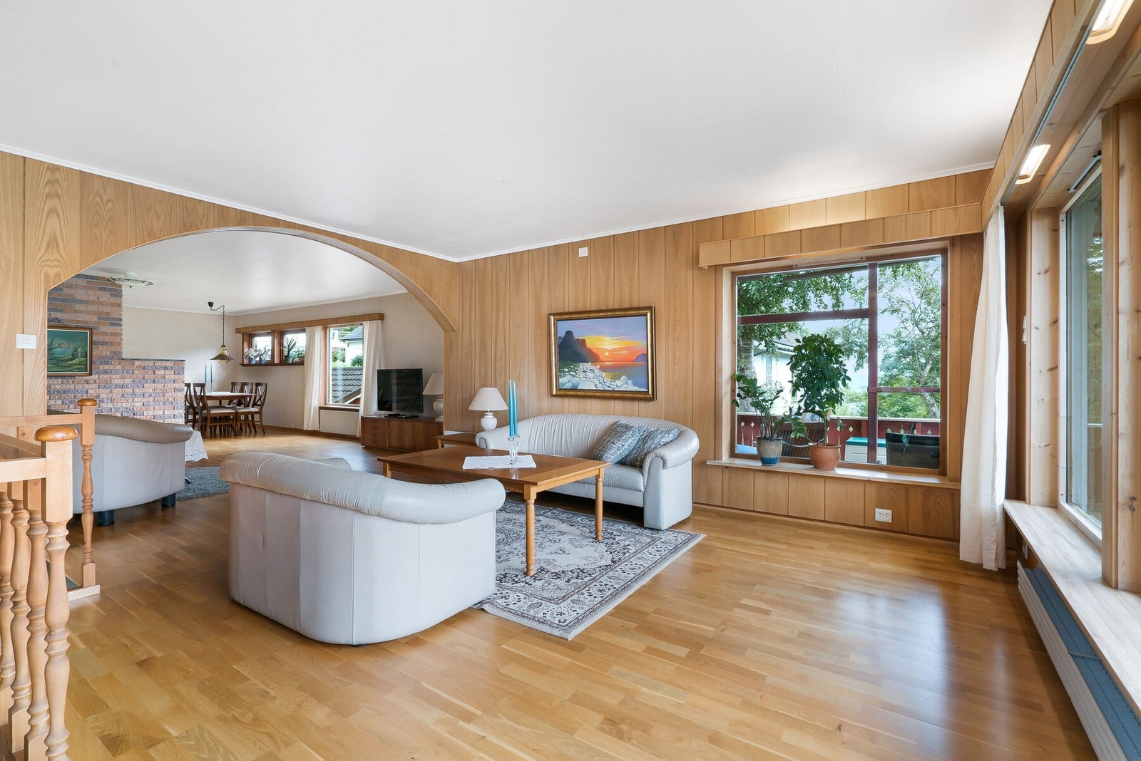 Gulvet på stuen er belagt med 3-stavs eikeparkett. Veggene har finérplank og tekstilstrier. Tekstilstriene har dog mistet heft mot vegg på flere steder. Galleribilde