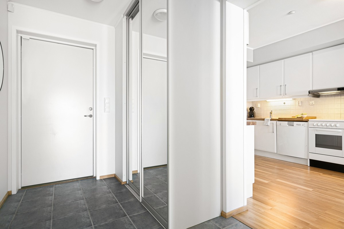 Entre med skyvedørsgarderobe og flislagt gulv med varmekabler
