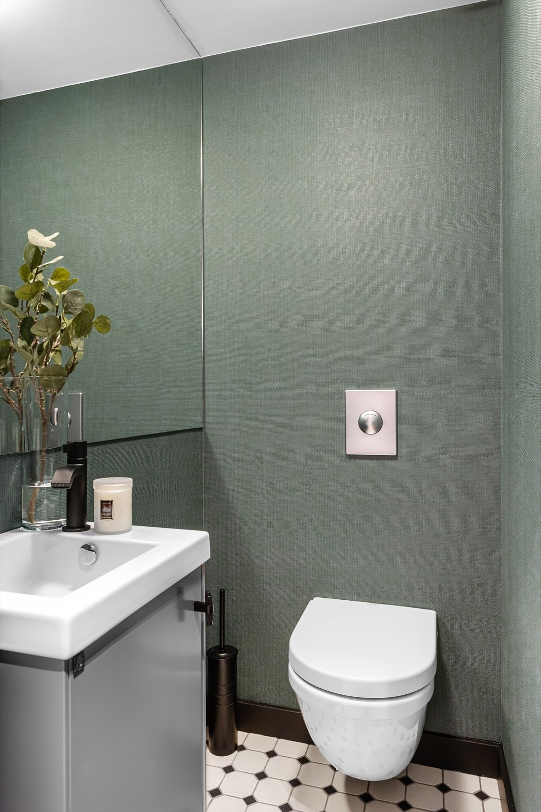 Toppmoderne og praktisk separat wc-rom bestående av vegghengt toalett, servantinnredning og speil. Galleribilde