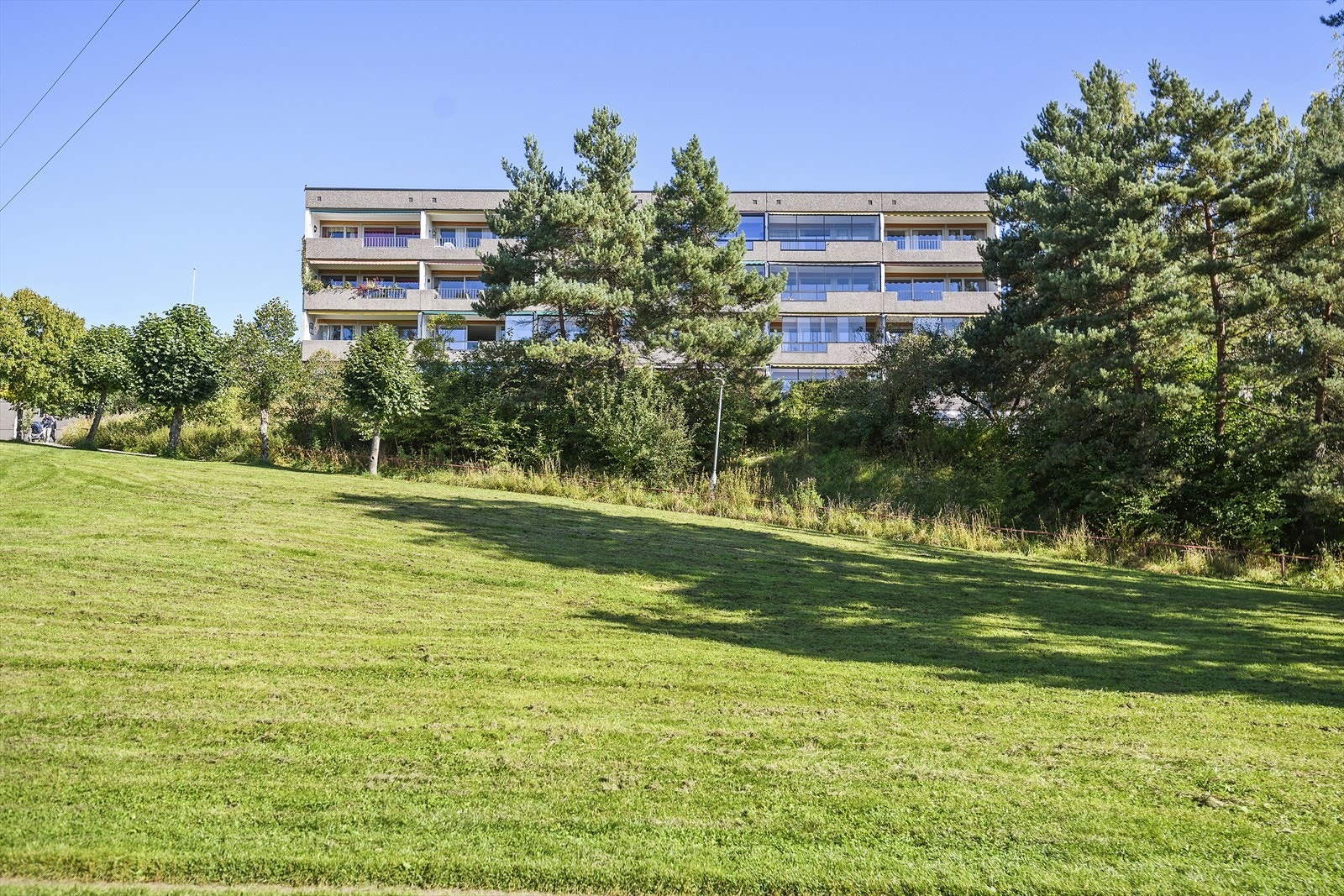 Blokken har særdeles fin beliggenhet i borettslaget med balkonger ut mot frie områder og svært gode solforhold Galleribilde