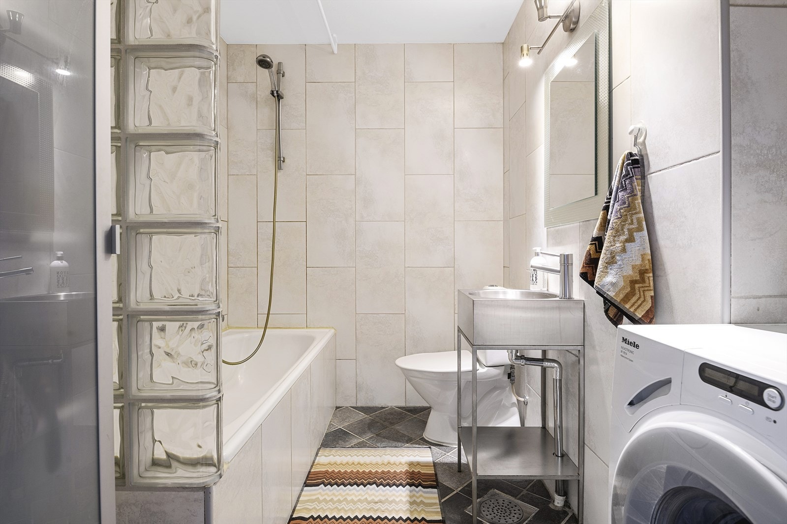 Pent flislagt bad fra 2006 med innmurt badekar, varmekabler i gulvet og opplegg for vaskemaskin og tørketrommel Galleribilde