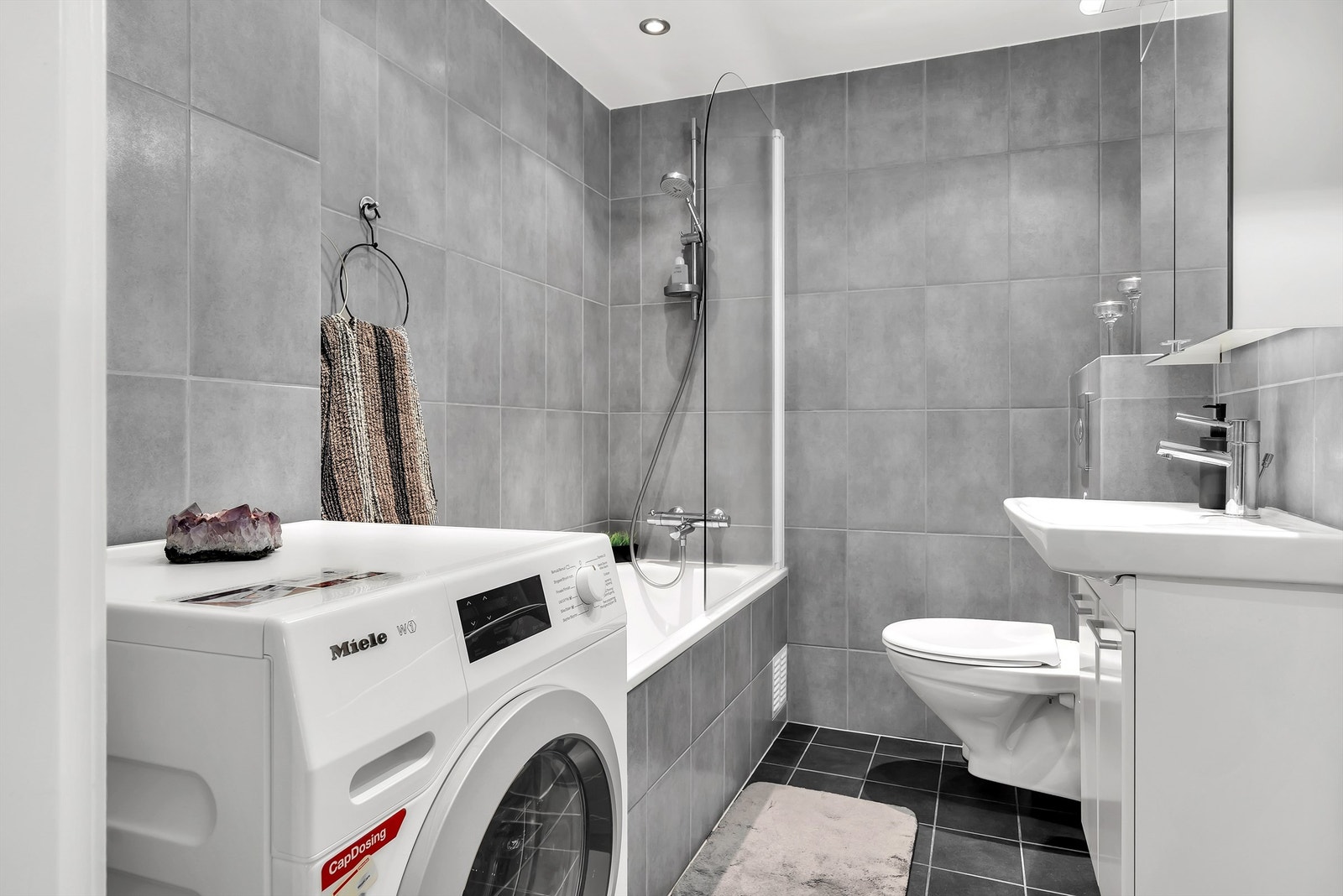 Baderom med opplegg til vaskemaskin, servantskap og vegghengt toalett. Varmekabler i gulvstøp. Galleribilde