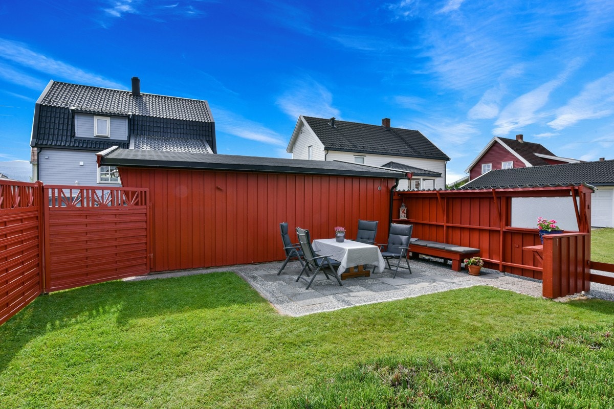 Ved garasjevegg mot nord, er det anlagt en hellelagt uteplass mot sydvendt del av hagen, og skjermet av tette, rødmalte levegger. Galleribilde