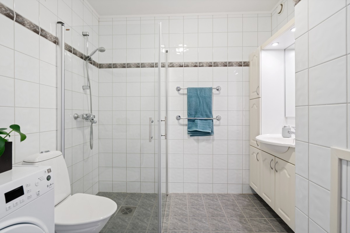 Badet er pent flislagt og har god skapinnredning