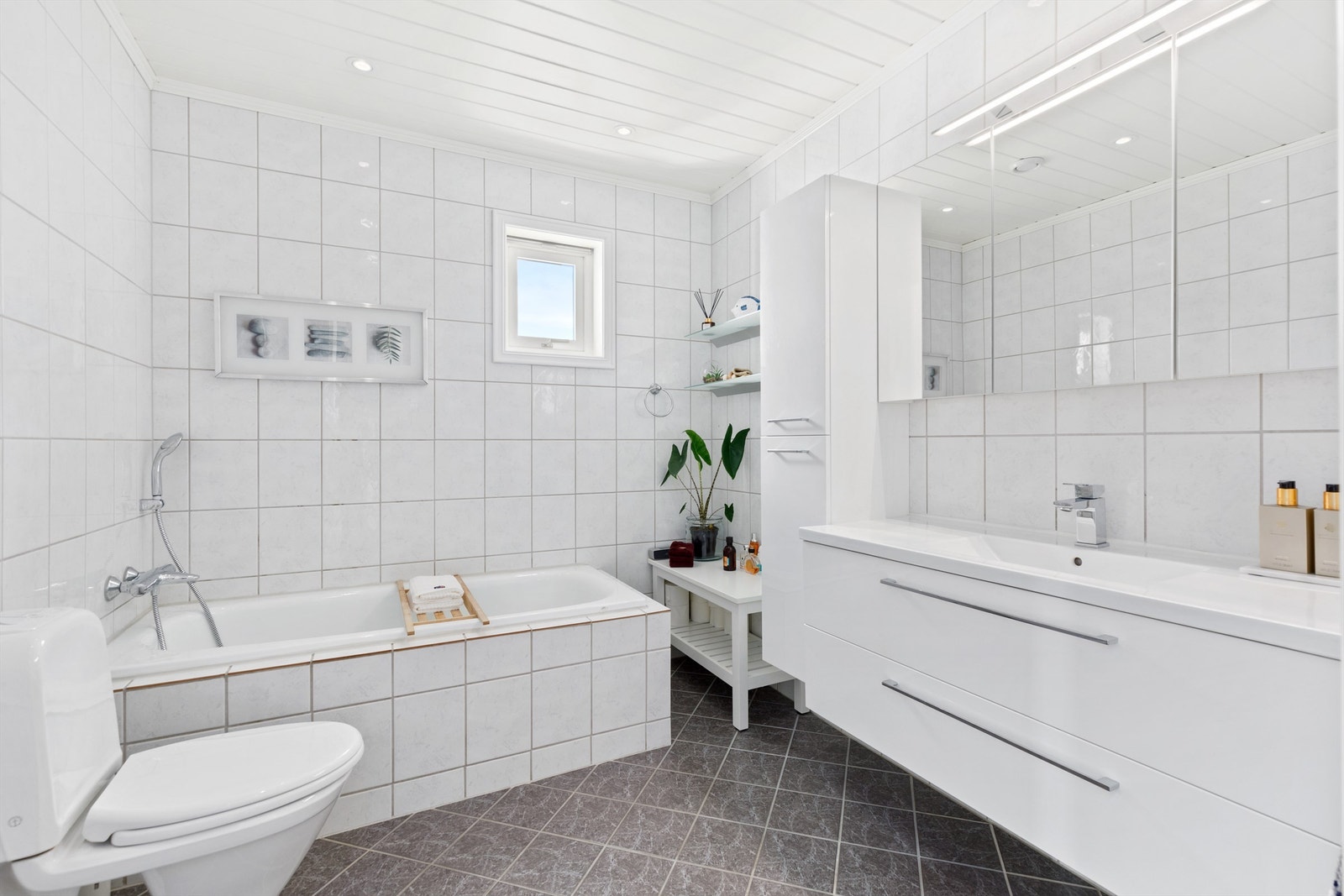 Bad fra byggeåret med varme i gulvet, innmurt badekar, toalett og innredning med heldekkende servant Galleribilde