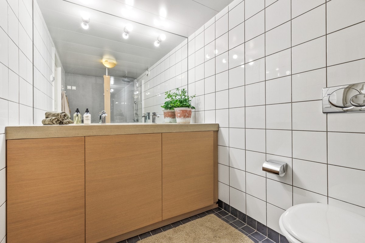 Det er montert en vaskemaskin fra Bosch som står i skapene under servantet. Galleribilde