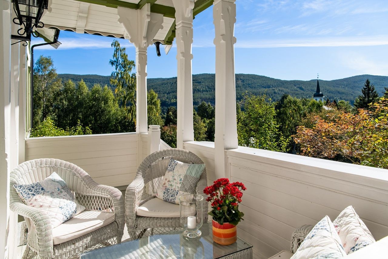 Terrasse med koselig utsikt mot nærliggende fjellområder og Stor-Elvdal kirke Galleribilde