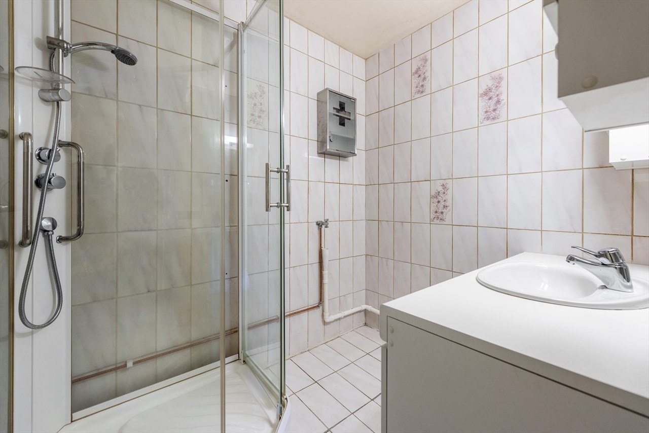 Badet har flislagte overflater, gulvvarme, dusjkabinett og opplegg for vaskemaskin. Galleribilde