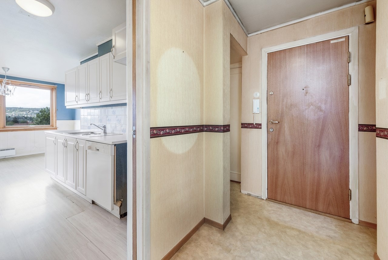 Entreen har en praktisk garderobenisje slik at det er enkelt å holde rommet fritt for klær og sko. Ved siden av inngangsdør med kikkehull og sikkerhetslås, er det montert dørtelefon. Galleribilde