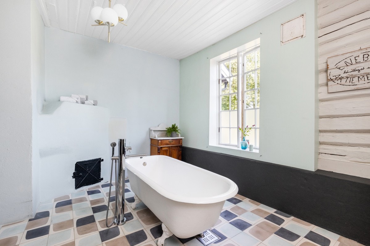 Et stilfullt badekar med løveføtter er rommets midtpunkt. Galleribilde