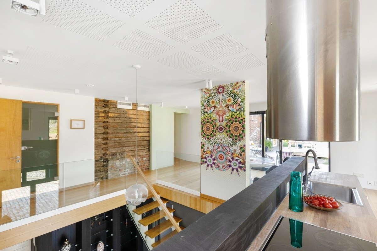 Kjøkken med spiseplass ved en vegg som er dekorert med en delikat tapet av Catalina Estrada. Galleribilde