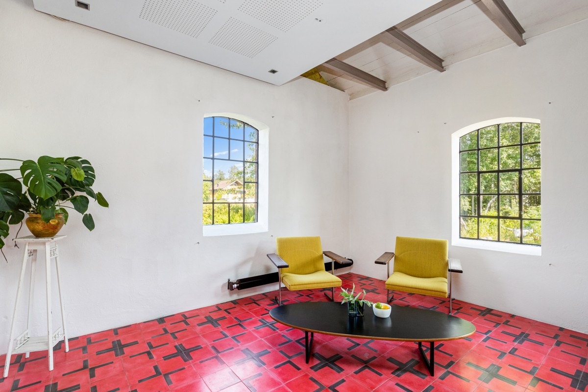 En del av stuen er innredet med kreative, håndlagde sementfliser på gulvet og downlights over. Galleribilde