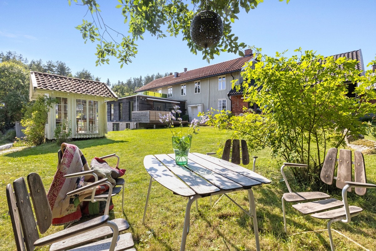Gjennom den hvite porten kommer du inn til Meieriskauveien 12 - en sjarmerende og stor eiendom hvor mulighetene er mange! Her kan både store og små trives i rolige og grønne omgivelser. Galleribilde