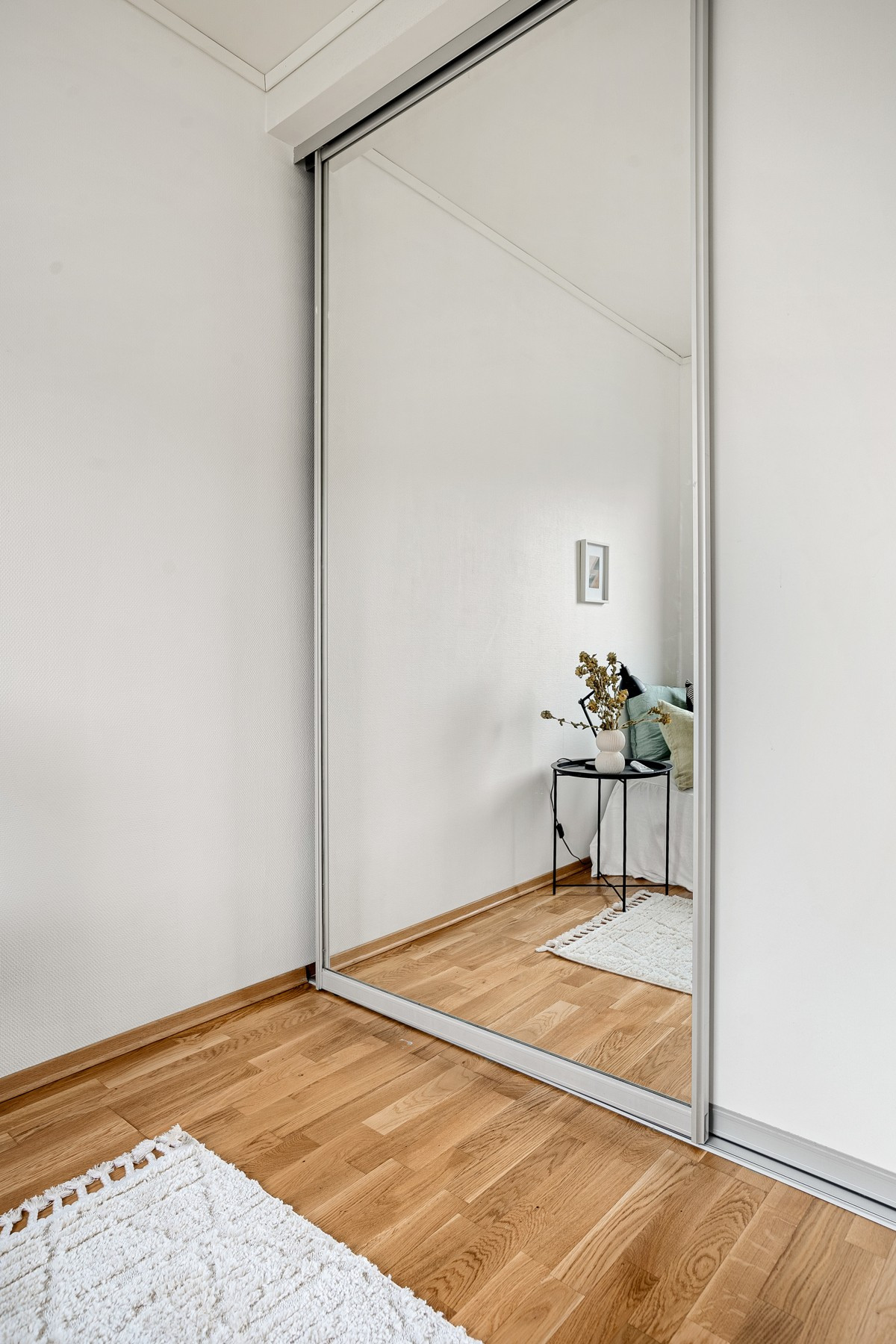 På soverommet er det en praktisk skyvedørsgarderobe