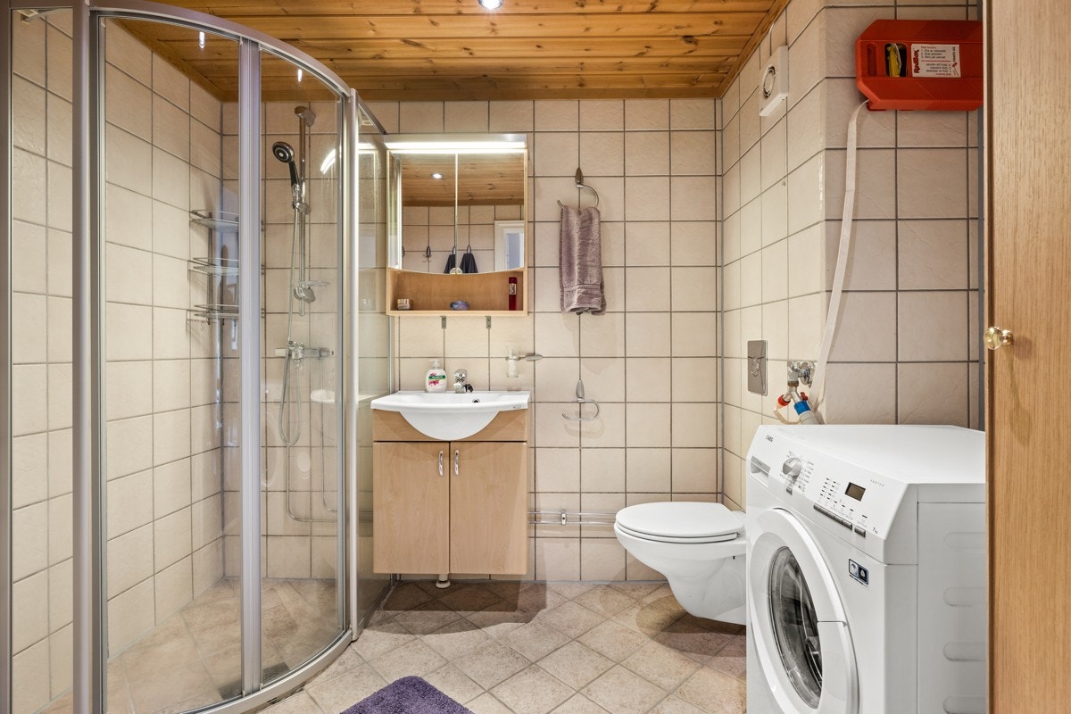 Meget romslig, flislagt baderom med både termostatstyrte varmekabler i gulv, opplegg for vaskemaskin og strømuttak for tørketrommel. Galleribilde