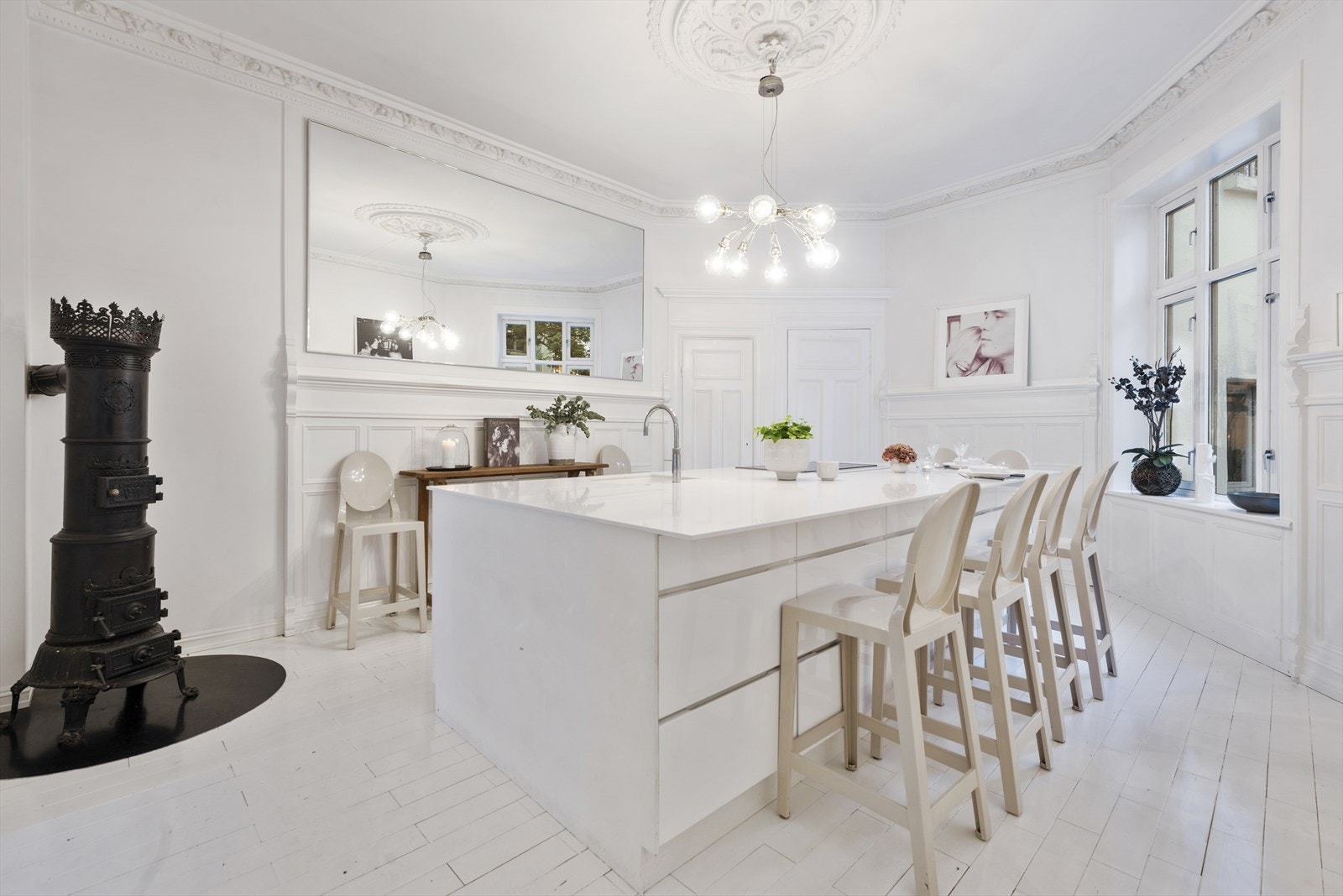 Rålekkert spisekjøkken fra Kvik og Silestone kjøkkenøy hvor det kan dekkes til 10 vender inn mot stille bakgård. Galleribilde