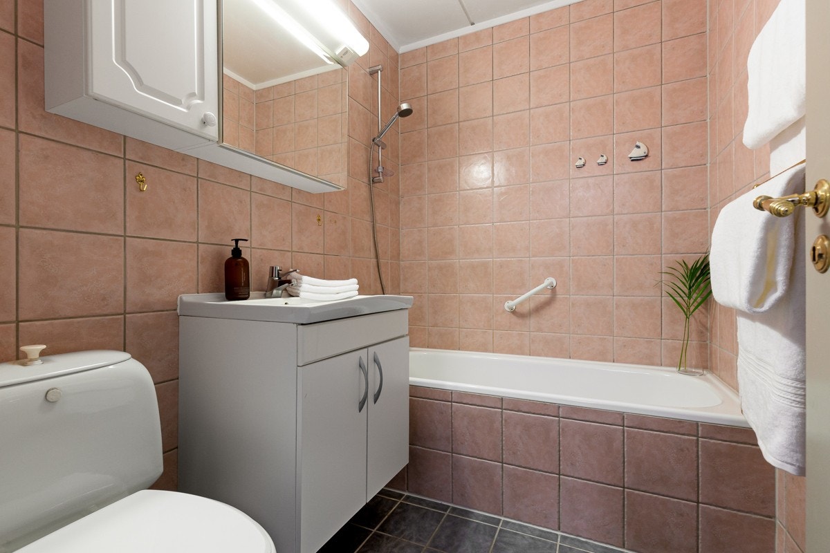 Badet er flislagt og utstyrt med blant annet gulvvarme, badekar og toalett. Galleribilde