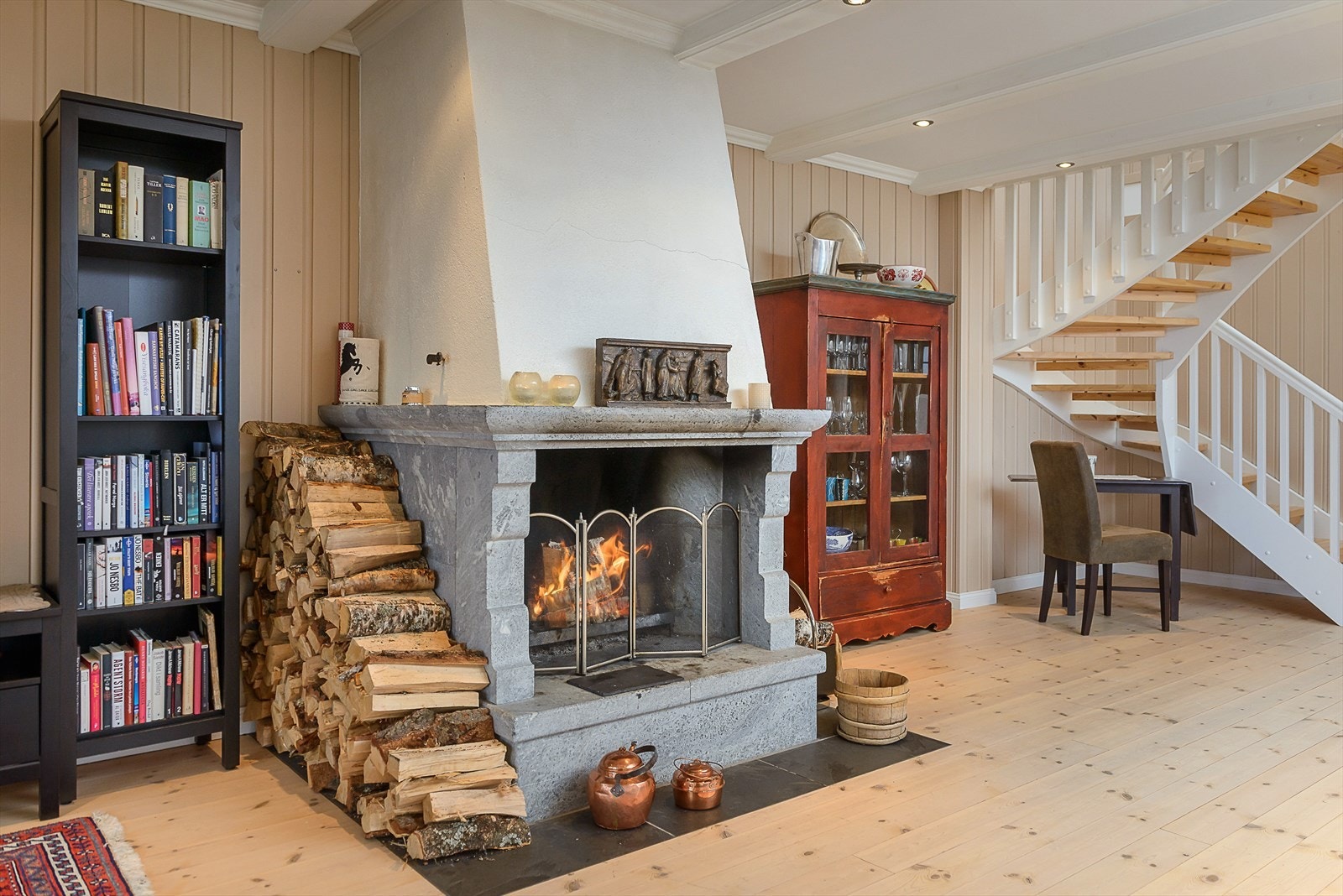 Sentralt i stuen er det en vakker, åpen klebersteinspeis. Galleribilde