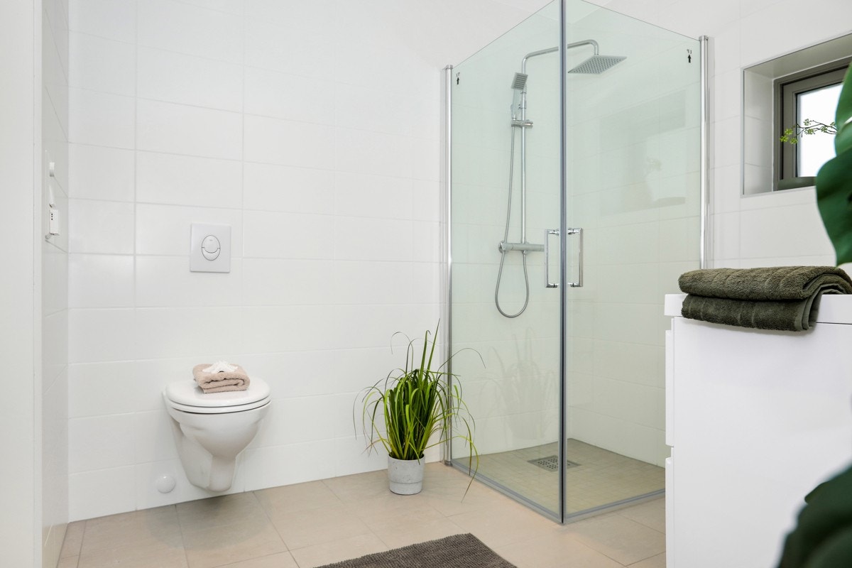 Badet har plassbesparende løsninger som vegghengt toalett og innfellbare dusjdører Galleribilde