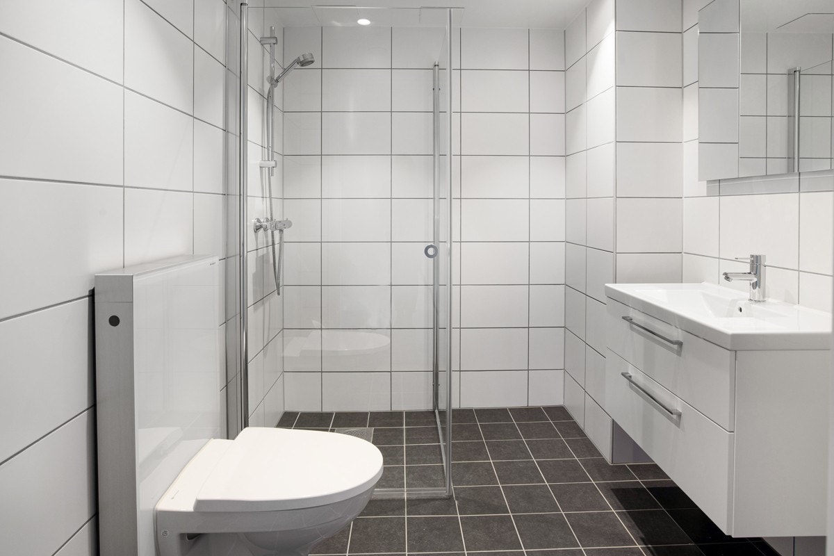 Bad med vegghengt-wc, servant og dusj med glassdører Galleribilde