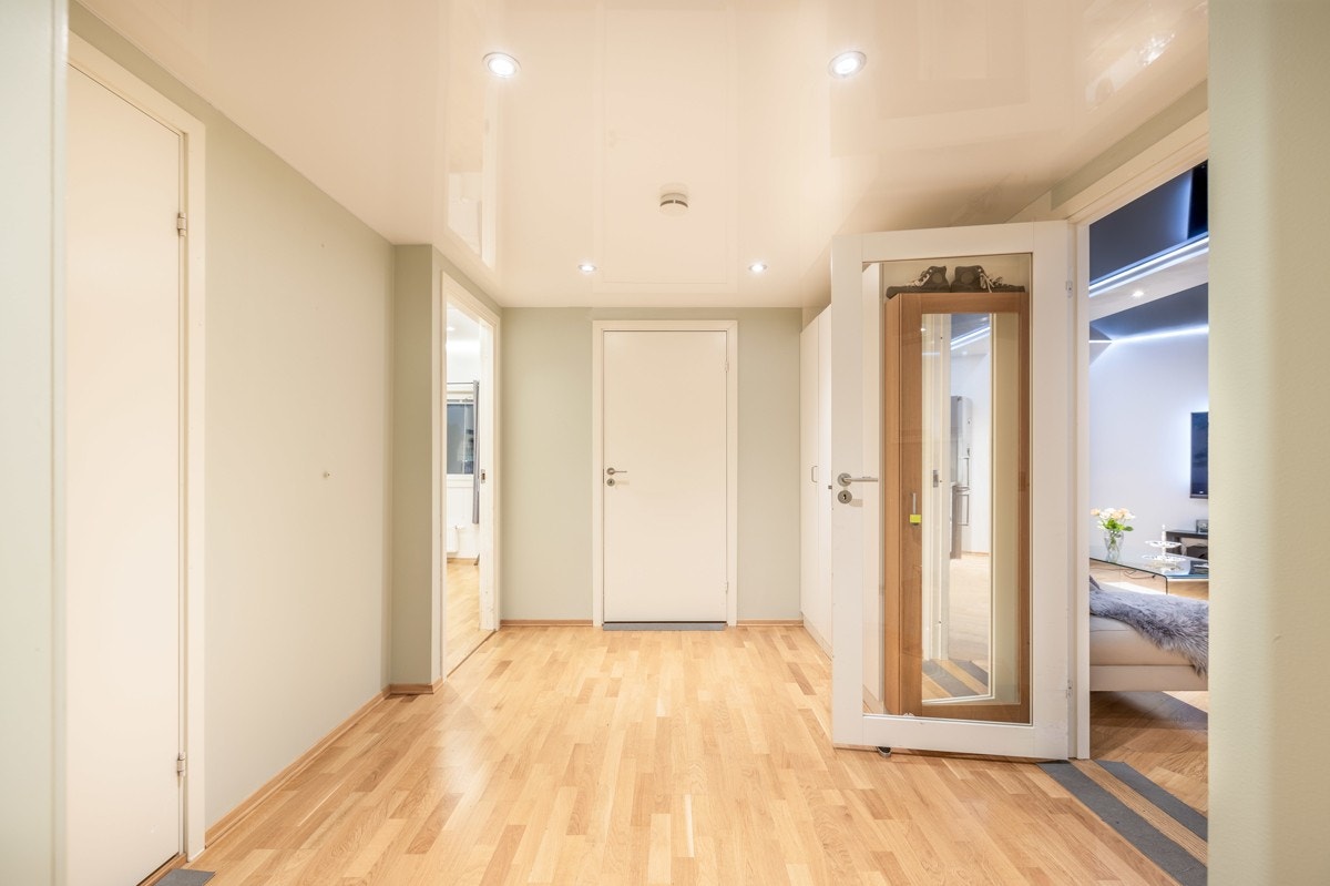Entreen gir et godt førsteinntrykk av leiligheten og stilfullt innredet med parkett på gulv og lyse vegger, noe som harmonerer med øvrige rom i leiligheten. Galleribilde