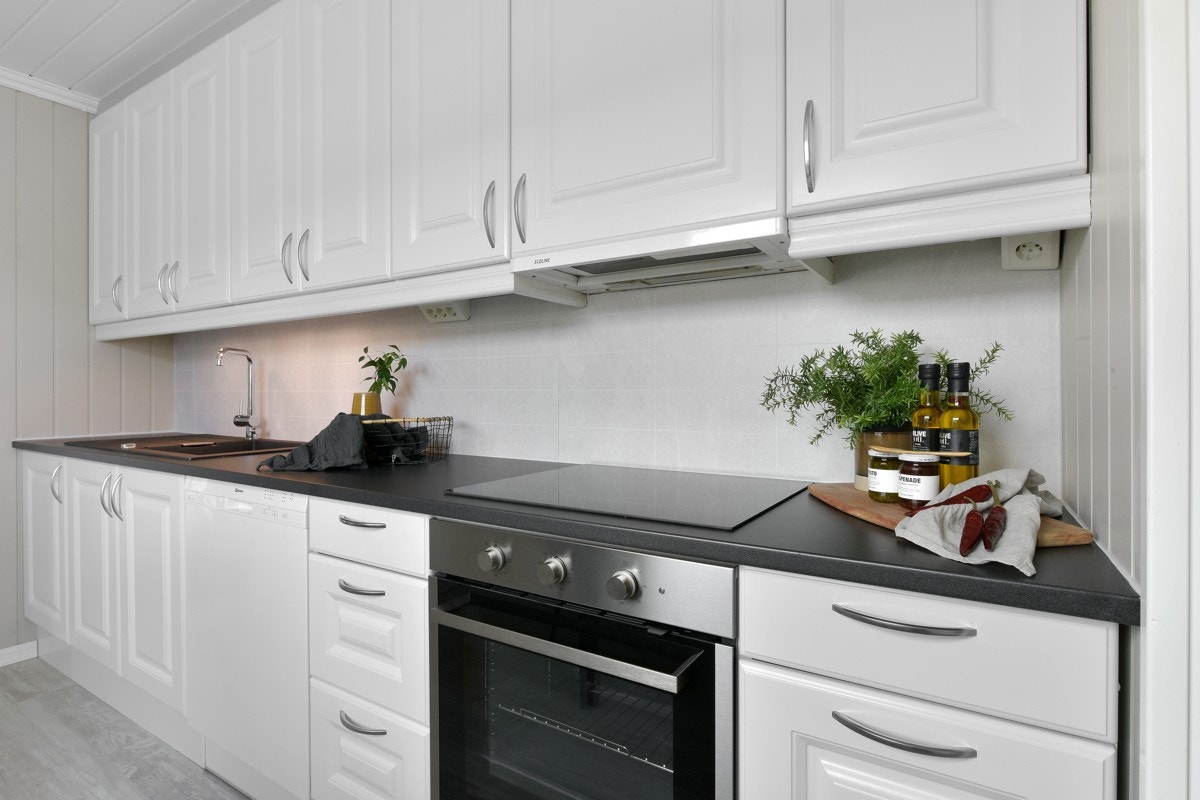 Kjøkkenet har god benke- og lagringsplass, innredning med profilerte fronter, belysning og Alloc kitchen wall på vegg mellom over- og underskap. Galleribilde