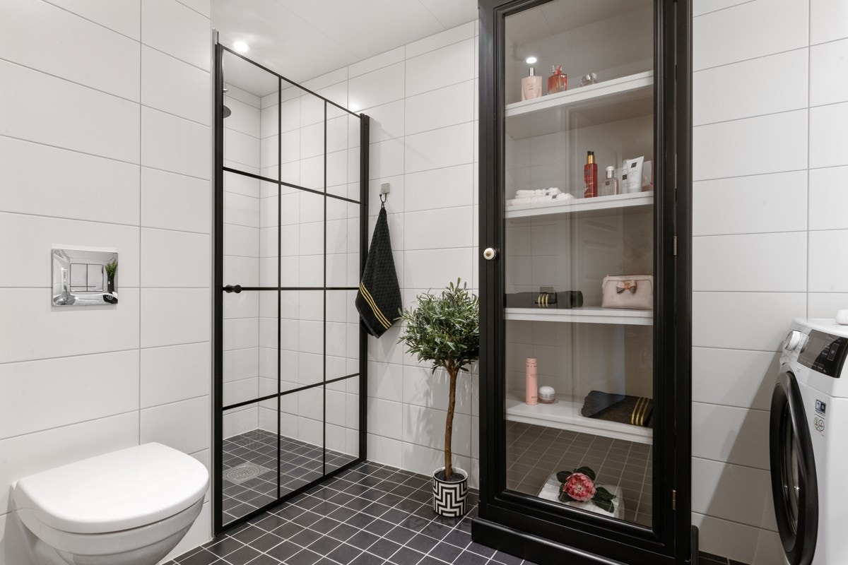 Lekkert bad med oppgradert dusjdør i herdet glass med sorte og trendy detaljer. Galleribilde