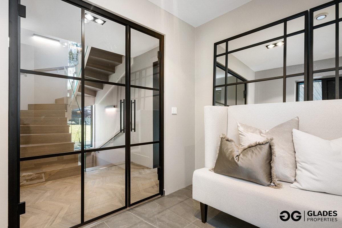 Fra carporten kan du gå tørrskodd inn i boligen. Entreen gir umiddelbart en godt førsteinntrykk med "New York" glassdører og vindusfelt til gangen innenfor. Entreen har marmorerte fliser på gulvet, gulvvarme, slette veggflater og italiensk designbelysning Galleribilde